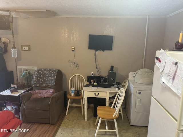 interior space featuring ornamental molding, washer / clothes dryer, a textured ceiling, and light tile patterned floors