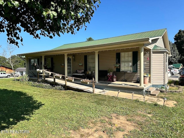 back of property with a lawn and covered porch