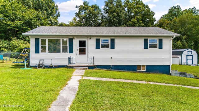 view of front facade with a front lawn and a storage unit