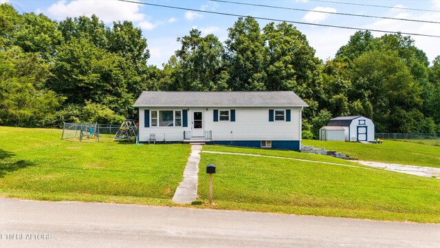 view of front of house featuring a storage shed and a front lawn