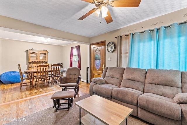 living room featuring ceiling fan and wood-type flooring