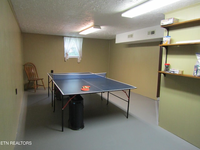 rec room featuring concrete flooring, visible vents, and a textured ceiling