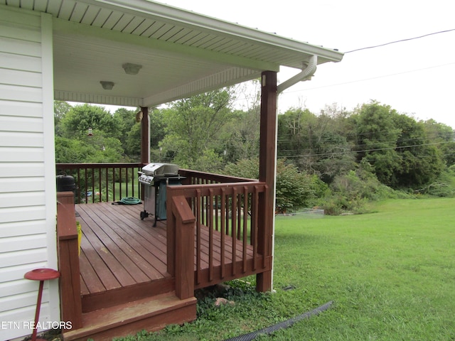 wooden terrace with a yard and a grill