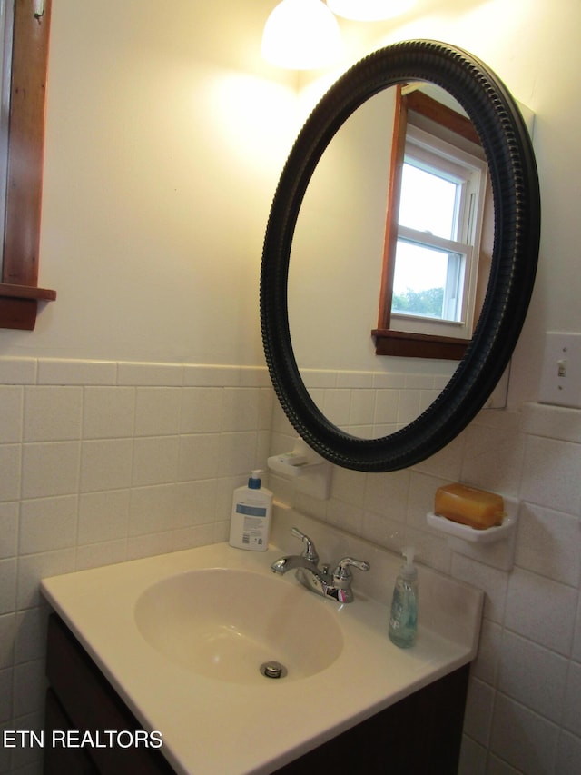 bathroom with tile walls, a wainscoted wall, and vanity