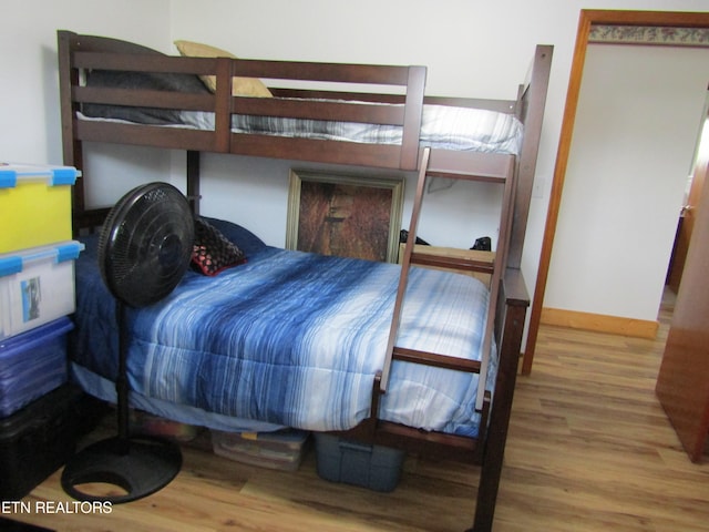 bedroom featuring wood finished floors and baseboards