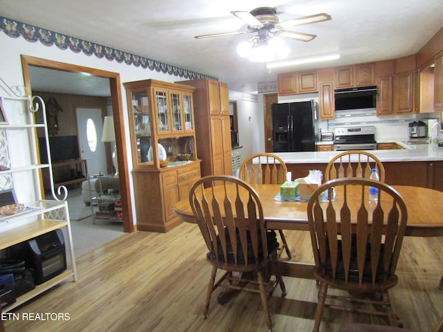 dining space featuring light wood-type flooring and ceiling fan