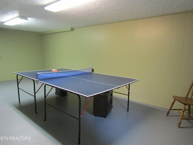 recreation room featuring concrete flooring and a textured ceiling