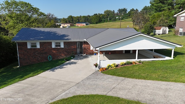 single story home with concrete driveway, metal roof, brick siding, and a front yard