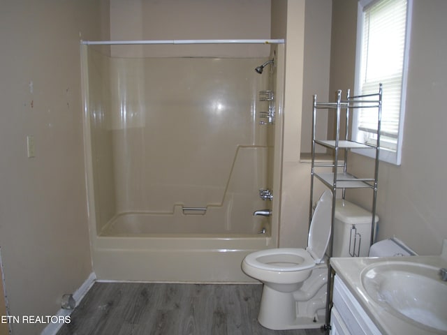 full bathroom with shower / bathtub combination, vanity, hardwood / wood-style floors, and toilet