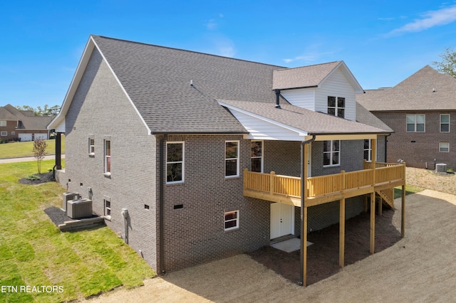 rear view of property featuring a yard and cooling unit