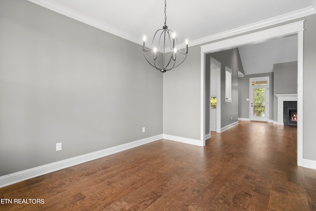 empty room featuring an inviting chandelier, ornamental molding, dark hardwood / wood-style floors, and lofted ceiling