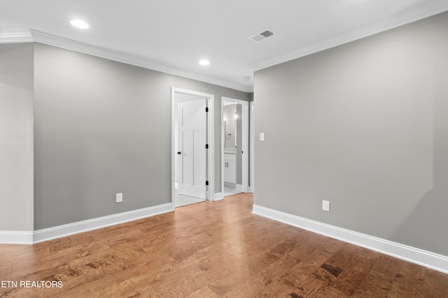 empty room featuring ornamental molding and wood-type flooring