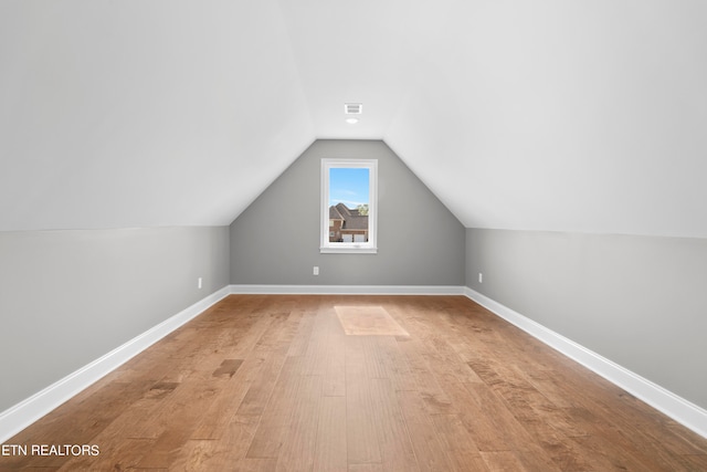 bonus room featuring vaulted ceiling and light wood-type flooring