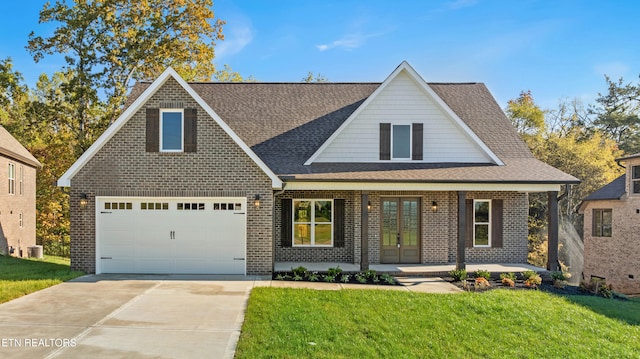 view of front of house featuring a front yard, a garage, and covered porch