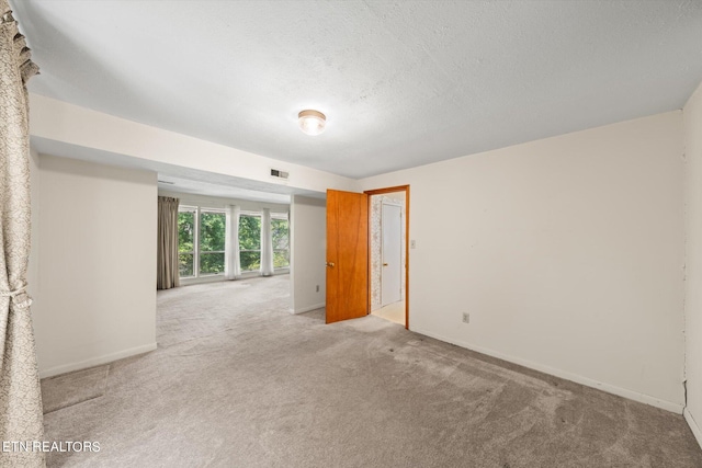 spare room with a textured ceiling and carpet