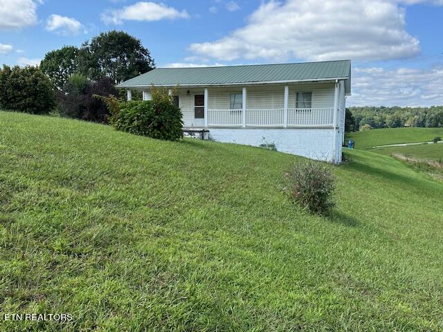 view of home's exterior featuring a yard and a porch