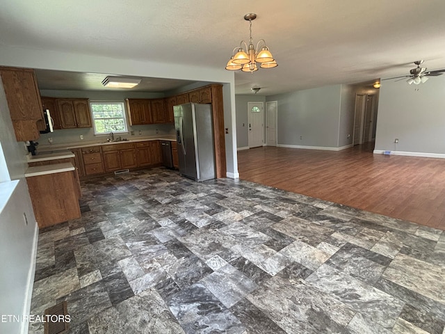 kitchen featuring pendant lighting, ceiling fan with notable chandelier, sink, dark hardwood / wood-style floors, and stainless steel fridge with ice dispenser