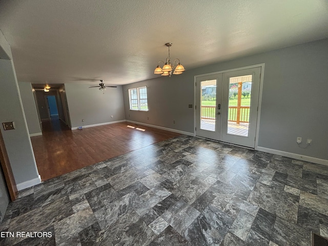 interior space with ceiling fan with notable chandelier, dark wood-type flooring, french doors, and a textured ceiling