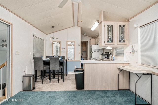 kitchen with vaulted ceiling, white fridge, pendant lighting, kitchen peninsula, and ceiling fan