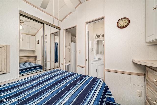 unfurnished bedroom featuring a closet, carpet floors, ensuite bath, lofted ceiling, and ceiling fan