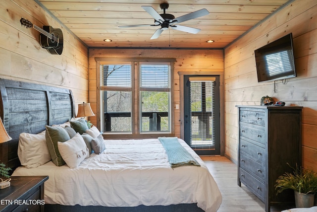 bedroom featuring ceiling fan, wooden walls, light hardwood / wood-style floors, and wood ceiling