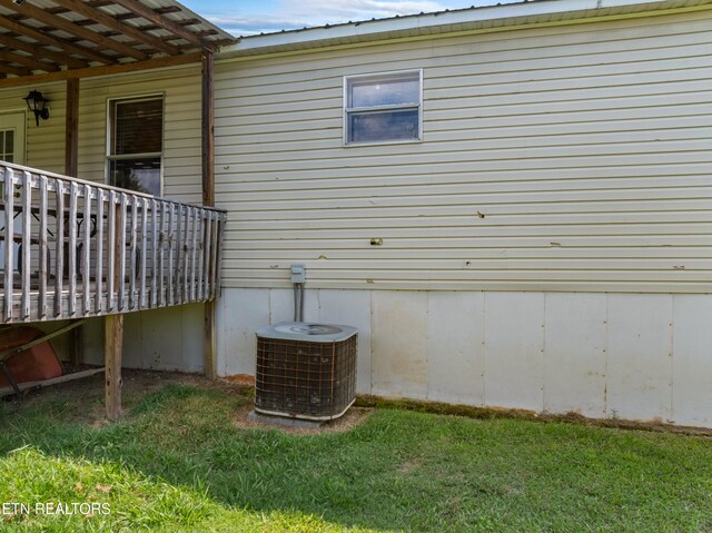 view of property exterior with central AC and a yard