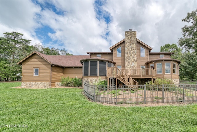 rear view of house with a yard and a wooden deck