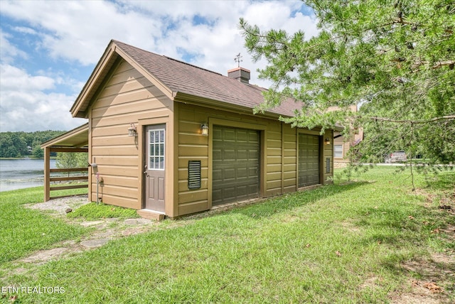 view of outbuilding featuring a water view and a yard