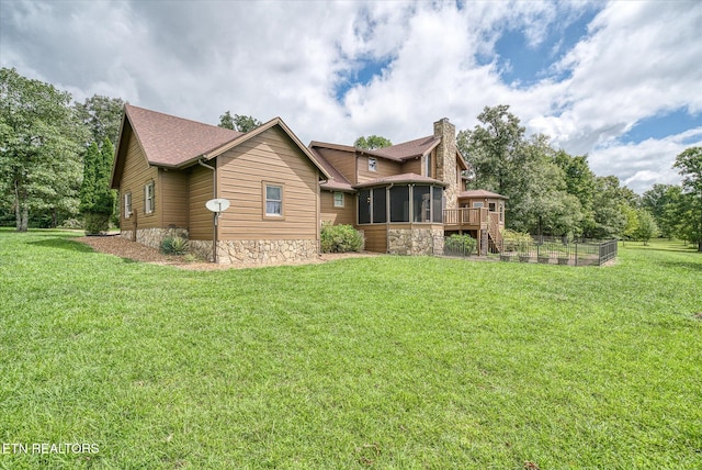 craftsman-style home featuring a wooden deck, a sunroom, and a front yard