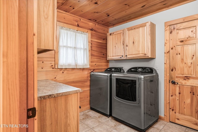 washroom featuring light tile patterned floors, washer and dryer, and cabinets