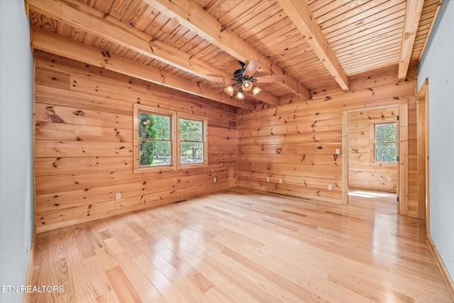 empty room with beam ceiling, wood ceiling, and light hardwood / wood-style flooring