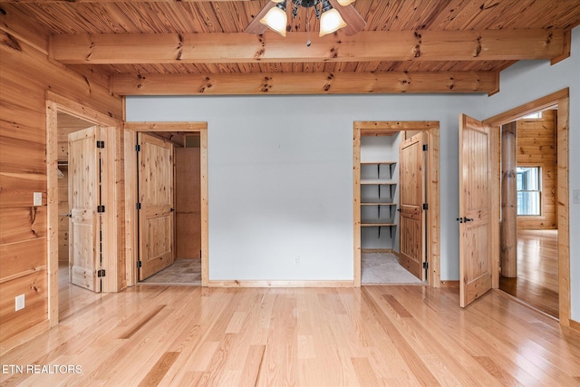 empty room featuring wood ceiling, light hardwood / wood-style flooring, ceiling fan, and beamed ceiling