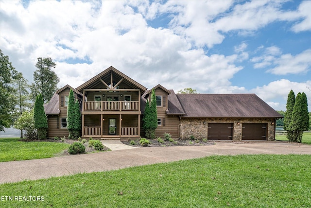 view of front of home featuring a balcony, a front yard, and a garage