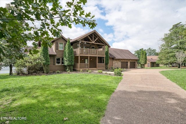 view of front of house with a balcony, a garage, and a front yard