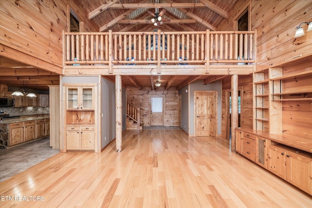 unfurnished living room with high vaulted ceiling, light hardwood / wood-style floors, wooden ceiling, and beam ceiling