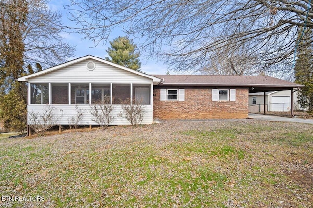 view of front facade with a carport, a sunroom, and a front yard