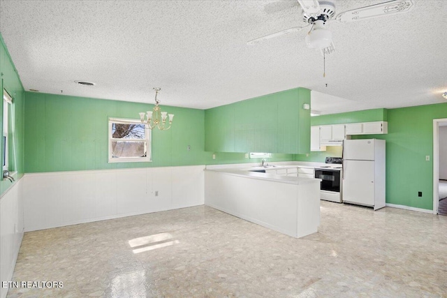 kitchen featuring pendant lighting, white cabinetry, sink, white appliances, and a textured ceiling