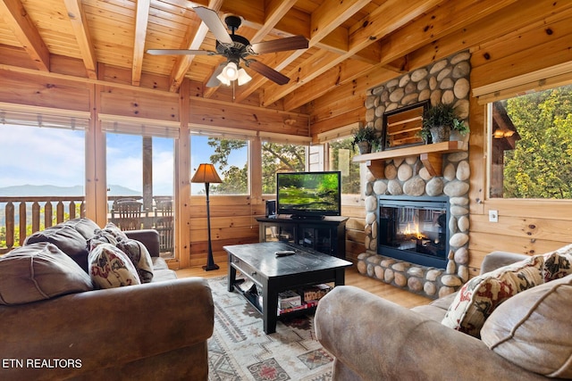 living area featuring beamed ceiling, wooden walls, wood finished floors, and wood ceiling