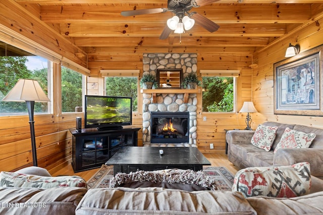living room featuring plenty of natural light, beamed ceiling, and wood finished floors