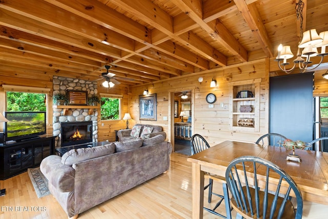 living area featuring beam ceiling, wood ceiling, wooden walls, wood finished floors, and ceiling fan with notable chandelier