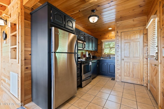 kitchen featuring wooden ceiling, wooden walls, stainless steel appliances, light tile patterned floors, and visible vents