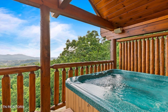 wooden deck featuring a mountain view and a hot tub