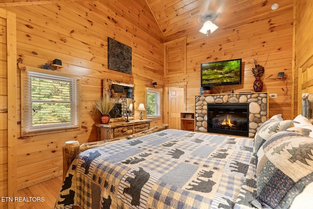 bedroom with multiple windows, high vaulted ceiling, and wooden walls