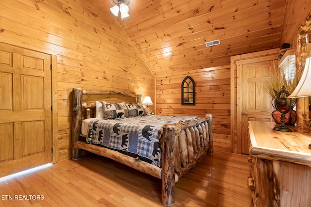 bedroom featuring wood-type flooring, wooden ceiling, lofted ceiling, and wooden walls
