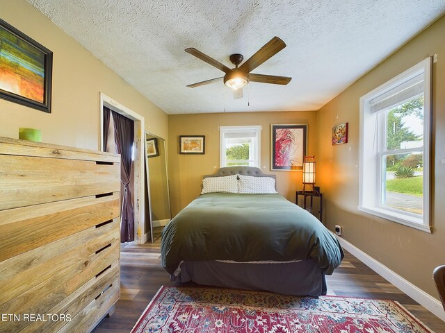 bedroom featuring ceiling fan, a textured ceiling, and dark hardwood / wood-style floors