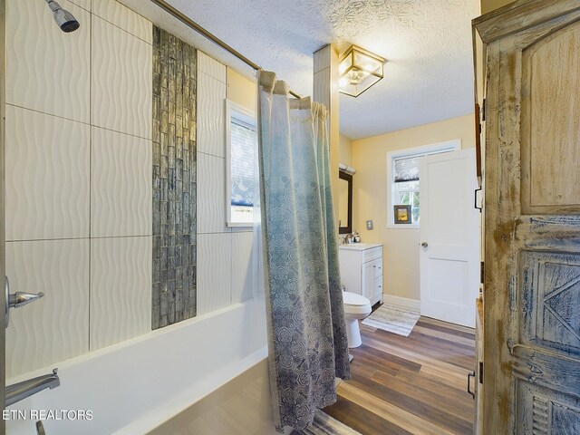 full bathroom featuring vanity, a textured ceiling, wood-type flooring, toilet, and shower / bath combo