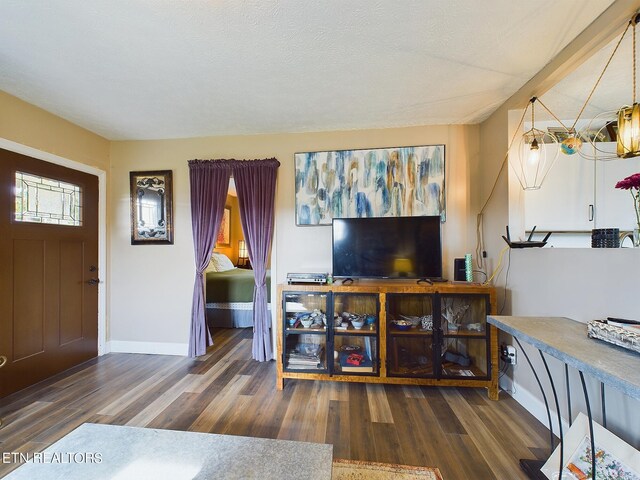 living room featuring a textured ceiling and dark wood-type flooring