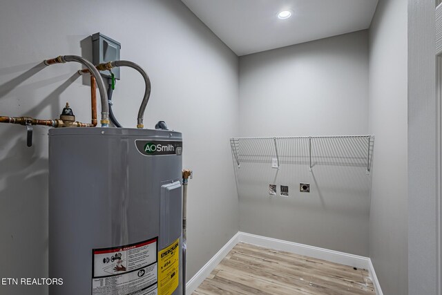 laundry room with hookup for a washing machine, electric dryer hookup, electric water heater, and light hardwood / wood-style floors