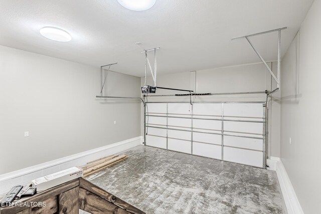 garage featuring a garage door opener and baseboards