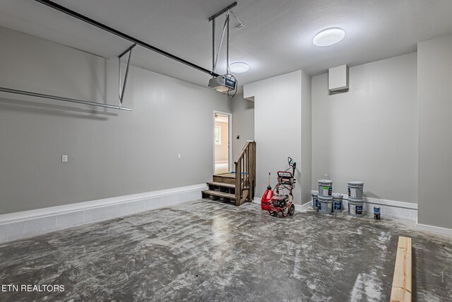 garage with a garage door opener and baseboards